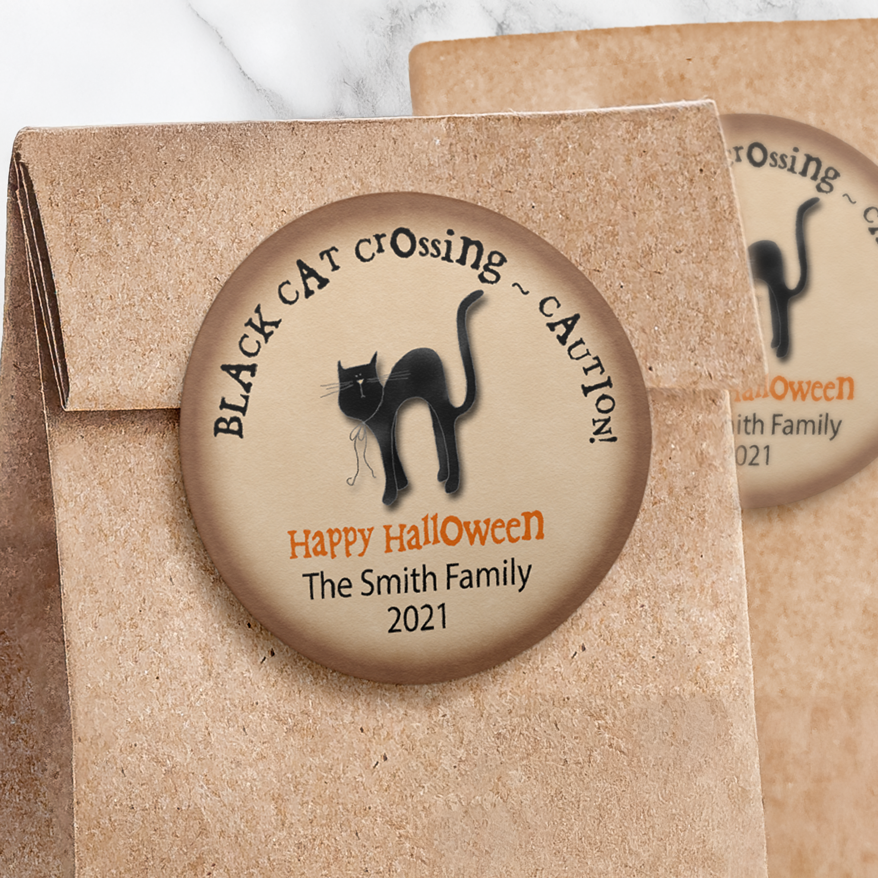 Round black cat sticker with brown background on paper trick or treat bag